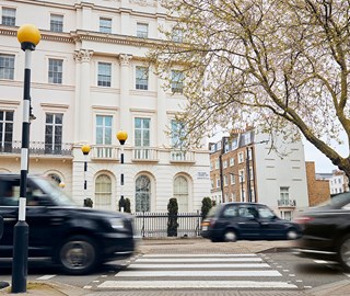 View of crossing and white residential  buildings in London, with black taxis