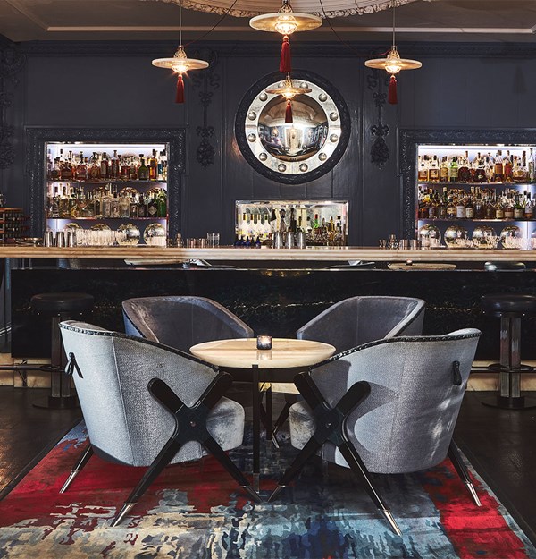 The Blue Bar: round table with chairs, and at the back of the room the bar with spirits.