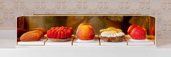 Cedric Grolet's 5 signatures for Summer 2024 lined up in a row; almond, raspberry tart, peach, lemon flower, vegan strawberry.